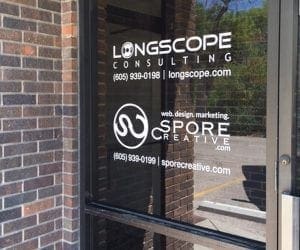 Longscope consulting and spore creative white vinyl lettering on a glass door